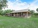 Elegant single-Gathering home with a metal roof, extensive porch, and a lush green lawn at 4880 Bannon Island Rd, Haines City, FL 33844