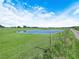 Serene pond surrounded by green pastures with a wooden fence adds natural beauty to the property at 4880 Bannon Island Rd, Haines City, FL 33844