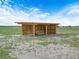 An open wooden three-stall structure situated on grass and sand with a blue sky overhead at 4880 Bannon Island Rd, Haines City, FL 33844