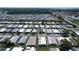 Aerial view of mobile home community with tidy homes and paved roads near waterway at 6739 Kensington Ne Dr, Winter Haven, FL 33881