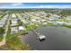 Aerial view of community featuring well-maintained homes and boat docks on a serene lake at 6739 Kensington Ne Dr, Winter Haven, FL 33881