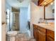 Well-lit bathroom features a glass enclosed shower, wood cabinets and neutral flooring at 6739 Kensington Ne Dr, Winter Haven, FL 33881