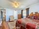 Comfortable bedroom featuring wood-look floors, light blue walls, ceiling fan and stylish red bedding at 6739 Kensington Ne Dr, Winter Haven, FL 33881