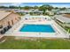 Aerial view of community pool with white picket fence, lounge chairs, and well-maintained surrounding area at 6739 Kensington Ne Dr, Winter Haven, FL 33881