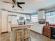 Bright kitchen features white cabinetry, stone countertops, and a butcher block island with seating at 6739 Kensington Ne Dr, Winter Haven, FL 33881
