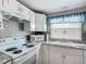 Bright kitchen features white cabinetry, tile backsplash, granite countertops, and stainless appliances at 6739 Kensington Ne Dr, Winter Haven, FL 33881