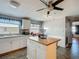 Bright kitchen features white cabinetry, stone countertops, and a butcher block island with storage at 6739 Kensington Ne Dr, Winter Haven, FL 33881