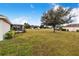 Spacious backyard with large tree and screened patio at 1518 Blue Sky Blvd, Haines City, FL 33844