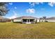 Spacious backyard with large grassy area and home view at 1518 Blue Sky Blvd, Haines City, FL 33844