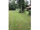 Well-manicured backyard, featuring a neatly kept lawn, landscaping and peaceful greenery at 4450 Old Berkley Rd, Auburndale, FL 33823
