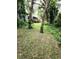 Lush backyard featuring a wooden deck surrounded by tropical foliage and mature trees at 4450 Old Berkley Rd, Auburndale, FL 33823