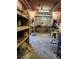 View of an unfinished basement space with shelves and metal doors at 4450 Old Berkley Rd, Auburndale, FL 33823