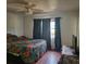 Bright bedroom features colorful bedding, ceiling fan, and natural light through window at 4450 Old Berkley Rd, Auburndale, FL 33823