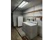 Functional laundry area with a washer, dryer, and storage shelves at 4450 Old Berkley Rd, Auburndale, FL 33823