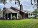 View of the house from the backyard, showcasing the screened porch and chimney at 416 Sandestin Dr, Winter Haven, FL 33884