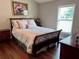 Well-lit bedroom with a comfortable bed, hardwood floors, and coordinated furnishings at 416 Sandestin Dr, Winter Haven, FL 33884