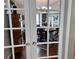 View through French doors of the dining room featuring hardwood floors and classic furnishings at 416 Sandestin Dr, Winter Haven, FL 33884