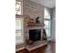 Living room fireplace with stone surround, wood mantle, and windows allowing natural light at 416 Sandestin Dr, Winter Haven, FL 33884