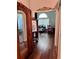 Hallway with hardwood floors leading to a room with desk and chair near a window at 416 Sandestin Dr, Winter Haven, FL 33884