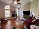 Cozy living room featuring vaulted ceilings, a stone fireplace, a ceiling fan, and a comfortable seating area at 416 Sandestin Dr, Winter Haven, FL 33884