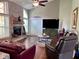 Open living room with fireplace, vaulted ceiling, hardwood floors, and comfortable leather furniture at 416 Sandestin Dr, Winter Haven, FL 33884