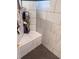Detail of the shower featuring white tiled walls, shower bench, and modern fixtures at 416 Sandestin Dr, Winter Haven, FL 33884