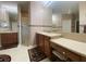 Large bathroom boasts double vanities, vanity area, clear glass shower, and tile flooring at 4577 Back Nine Dr, Winter Haven, FL 33884