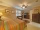 Bedroom features tile flooring, neutral walls, ceiling fan, and furniture at 4577 Back Nine Dr, Winter Haven, FL 33884