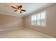 Bright bedroom boasts tile flooring, ceiling fan, white trim, and a window with white shutters at 4577 Back Nine Dr, Winter Haven, FL 33884