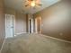 Neutral carpeted bedroom with ceiling fan and multiple doors and a glimpse into an adjoining room at 4577 Back Nine Dr, Winter Haven, FL 33884