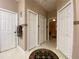 Hallway with 3 doors, neutral paint, decorative rug, and tile flooring at 4577 Back Nine Dr, Winter Haven, FL 33884