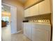 The Laundry Room with washer, dryer and cabinetry opens up to a dining area at 4577 Back Nine Dr, Winter Haven, FL 33884