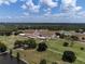 Aerial view of golf course, clubhouse, tennis courts, and pond at 6168 Arborea Dr, Lake Wales, FL 33898