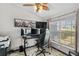 Comfortable bedroom with a large window, modern ceiling fan, and setup for gaming, providing a relaxing retreat at 1396 Lucerne Loop Ne Rd, Winter Haven, FL 33881