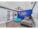 Vibrant bedroom with blue accent wall, playful decor, and cozy seating, creating a fun and inviting space at 1396 Lucerne Loop Ne Rd, Winter Haven, FL 33881
