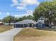 Inviting blue home with a long driveway and a lush green lawn at 1396 Lucerne Loop Ne Rd, Winter Haven, FL 33881
