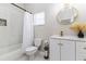 Bright bathroom featuring a shower/tub combo, toilet, and vanity with round mirror and decorative accents at 6047 Cason Way, Lakeland, FL 33812