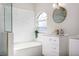 Bathroom vanity, tub with white marble wall, and a round mirror at 6047 Cason Way, Lakeland, FL 33812