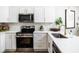 Well-lit kitchen with stainless steel appliances, white cabinets, and modern hardware at 6047 Cason Way, Lakeland, FL 33812