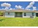 Inviting backyard features a covered patio and a lush green lawn, perfect for outdoor relaxation and entertaining at 2123 Cartgate Lane, Winter Haven, FL 33884