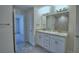 Well-lit bathroom with double sinks and a large mirror, offering a functional and stylish space at 2123 Cartgate Lane, Winter Haven, FL 33884