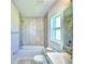 Bright bathroom with a window over the toilet and updated tile in the shower at 2123 Cartgate Lane, Winter Haven, FL 33884