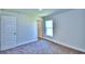 Bright, carpeted bedroom features neutral walls, white trim, a window, and a paneled interior door at 2123 Cartgate Lane, Winter Haven, FL 33884