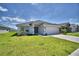 Well maintained single story home featuring an attached two car garage and lush green lawn at 2123 Cartgate Lane, Winter Haven, FL 33884
