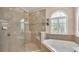 Bathroom with glass shower, soaking tub, and elegant tile at 318 Crescent Ridge Rd, Auburndale, FL 33823