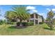 Two-story house with landscaping and a large palm tree at 318 Crescent Ridge Rd, Auburndale, FL 33823