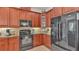 Well-equipped kitchen featuring wood cabinets and black appliances at 318 Crescent Ridge Rd, Auburndale, FL 33823