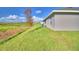 Single story home with gray exterior, grassy backyard, and conservation view at 4081 Tullamore Ln, Auburndale, FL 33823