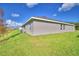 Single story home with gray exterior, grassy backyard, and AC unit at 4081 Tullamore Ln, Auburndale, FL 33823