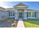 Front entrance with a teal door and landscaping at 4081 Tullamore Ln, Auburndale, FL 33823